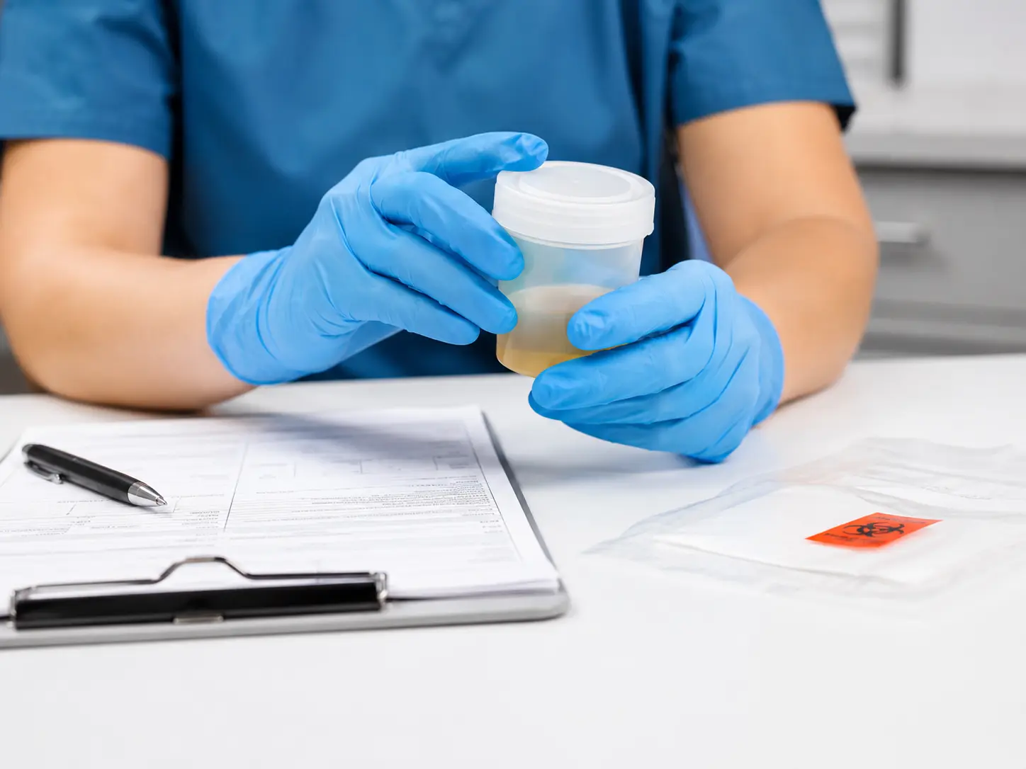 A collector performing a DOT urine specimen collection with chain-of-custody paperwork